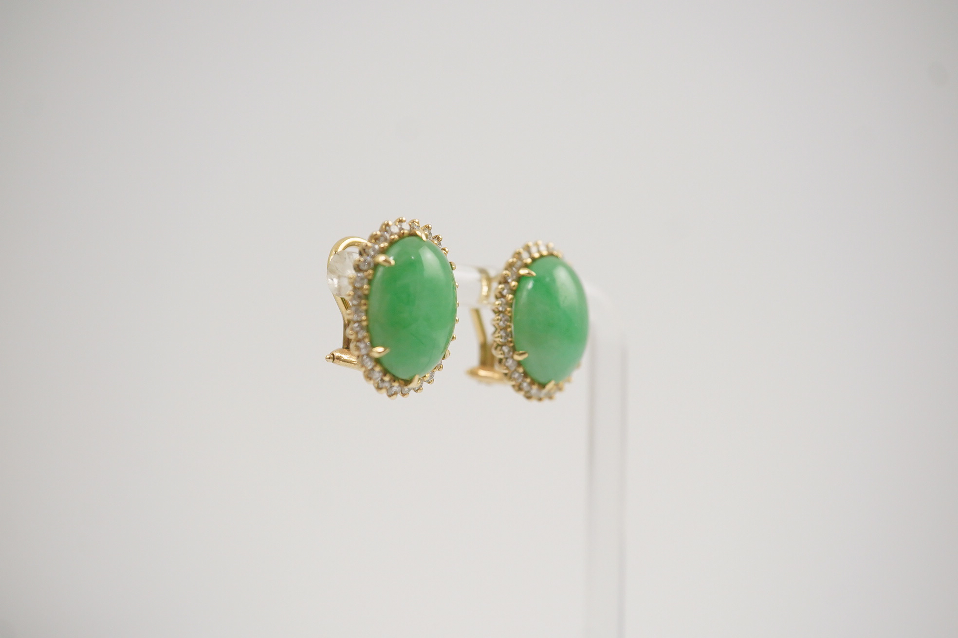 A pair of mid 20th century gold, cabochon jade and diamond cluster set oval earrings